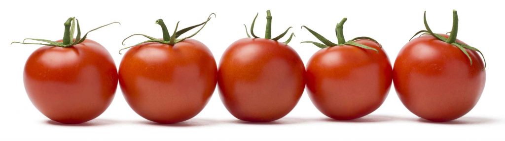 Five tomatoes in a row. This red vegetable is bursting with lycopene, a good-for-you phytonutrient.
