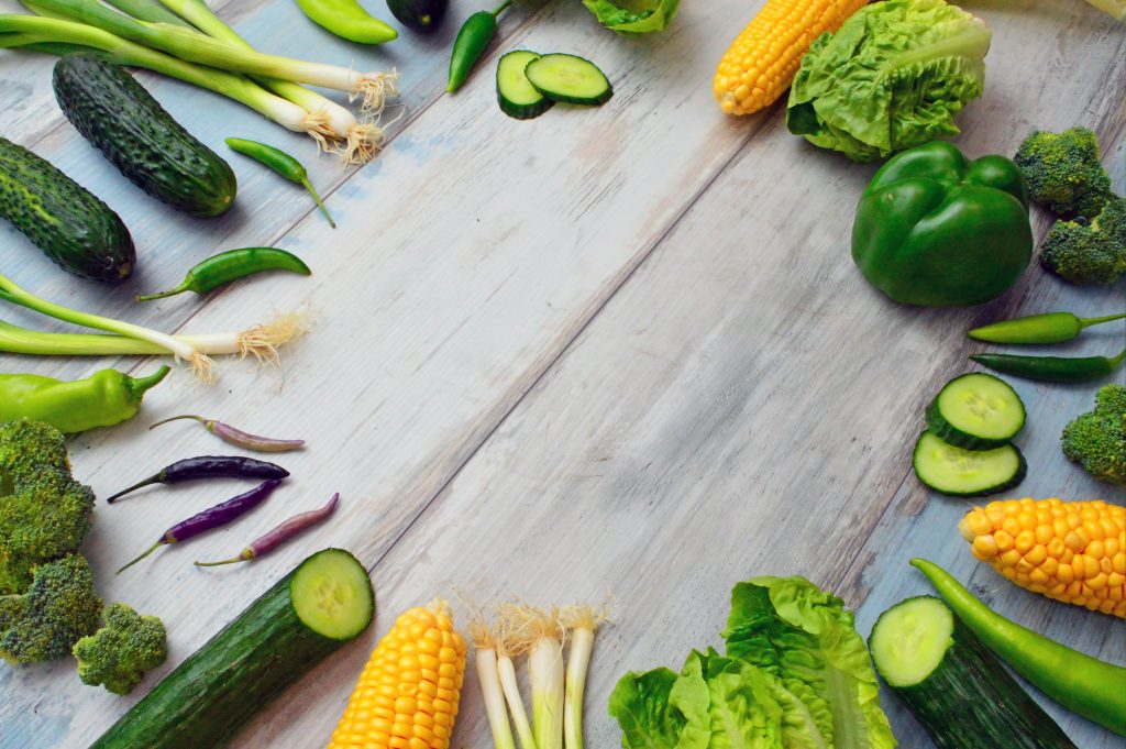 Broccoli, zucchini, corn and other colorful vegetables on a cutting board. Dark green, yellow and orange plants like these are rich sources of the phytonutrient lutein.
