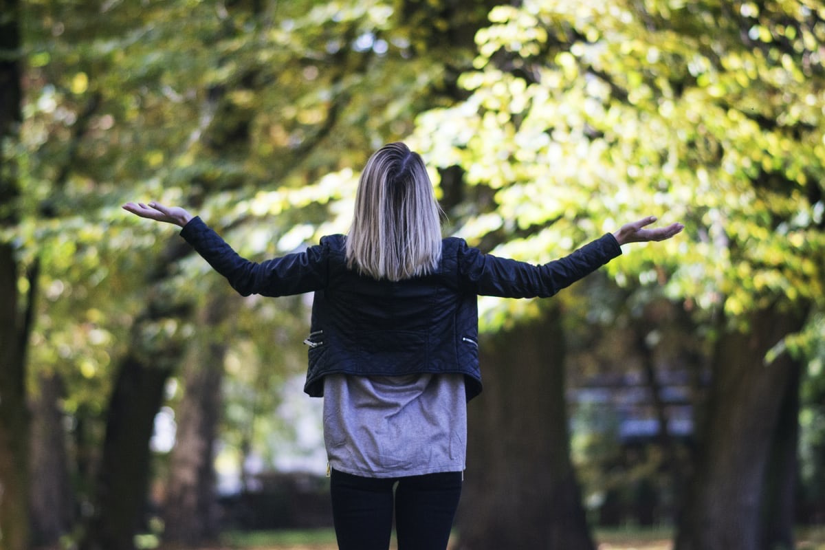 Women among trees looking skyward with open arms. When you find your why, it’s easier to succeed in health, life and business.