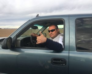 Salvador (Chava) Ramirez gives the thumbs up from the cab of his truck. Chava is lead irrigator and operator for sophisticated tillage and harvest equipment at Trout Lake Farm East. Ephrata, Wash, March 2020. Photo: Darwin Hintz.