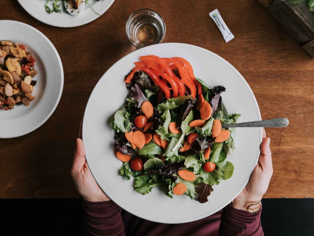 A green salad with assorted vegetables. Many vegetables are a natural source of inulin, chicory root and other beneficial prebiotics that help activate the production of beneficial bacteria in the gut.