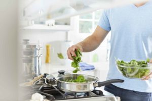 Cooking with spinach. The MIND diet includes at least six servings of spinach and other green leafy veggies each week.