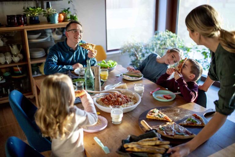 A family gathers around a table to enjoy a meal. Ground flaxseeds added to salads, pastas, breads and other foods help increase your intake of omega-3 fatty acids.