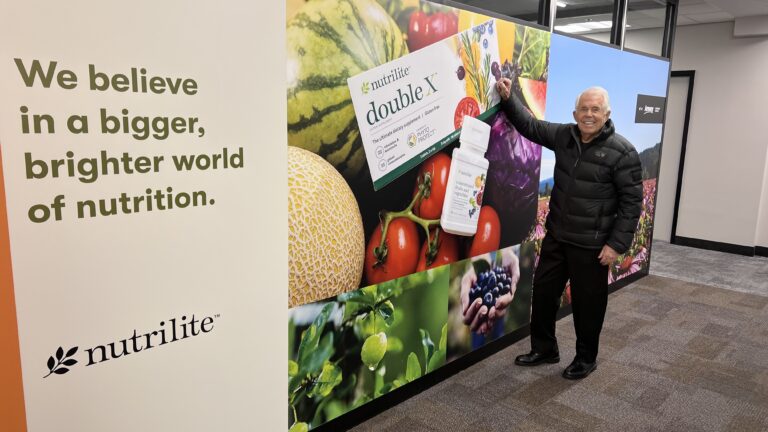 Dr Sam standing beside a double X product display